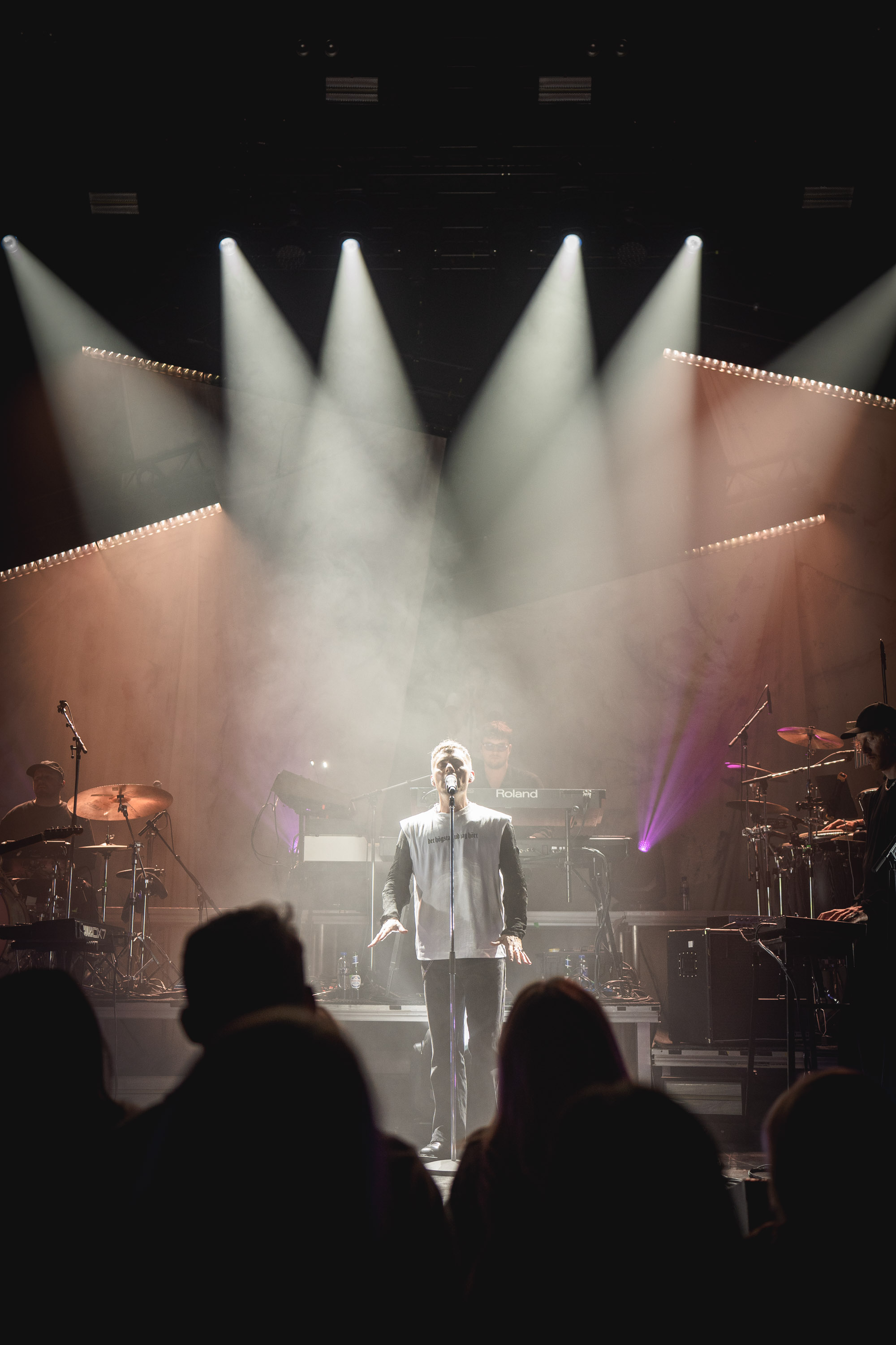 Oskar Linnros and his band beneath white spotlights