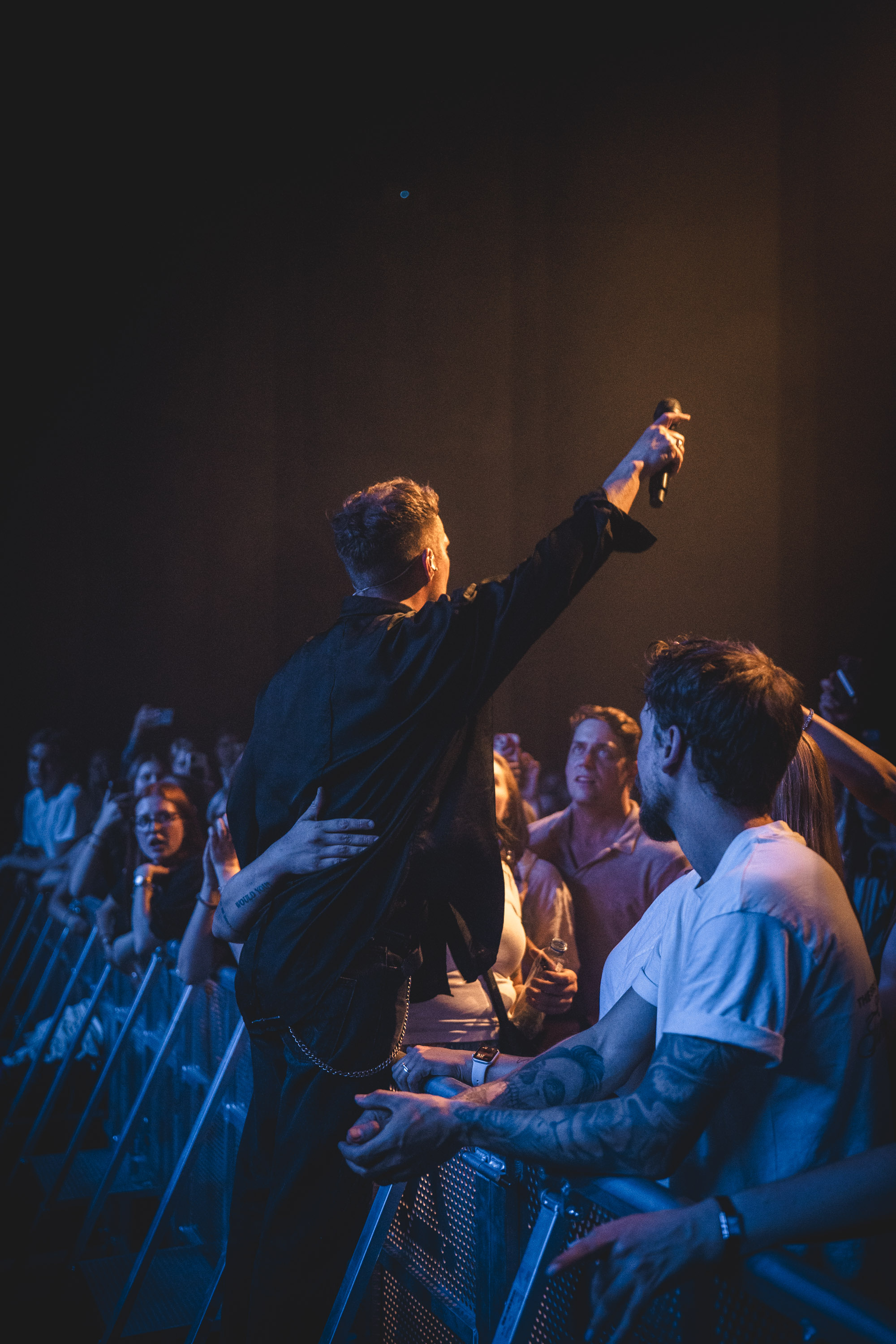 Oskar Linnros lifting the microphone toward the audience